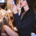 woman in black long sleeve shirt sitting on brown wooden chair